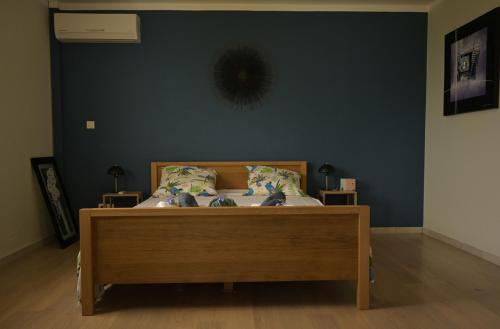 a bed in a bedroom with a blue wall at Vert Pré - Sublime maison avec vue imprenable in Croix Odilon