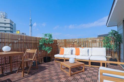 a patio with a couch and chairs on a balcony at 凪ノ家曳舟 Naginoya Hikihune in Tokyo