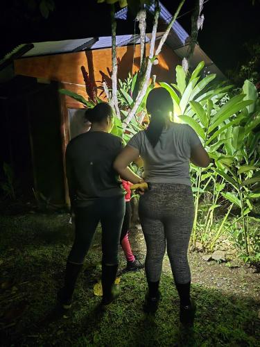 two women and a child looking at a garden at night at Boca Tapada Inn in Boca Tapada