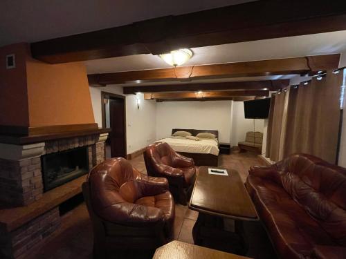 a living room with leather furniture and a bed at RRR Apartmány 1 in Bojnice