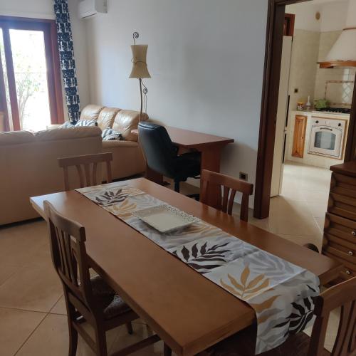 a kitchen and living room with a wooden table and chairs at CaSaM in Maruggio