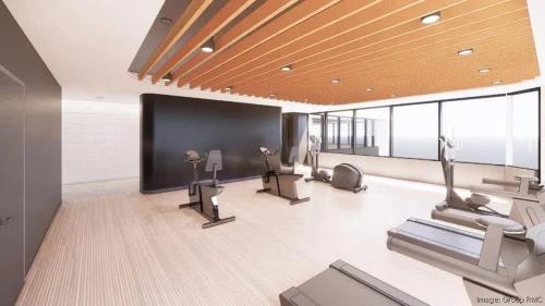 a gym with cardio machines and a flat screen tv at CozySuites Sky Central #21 in Cincinnati