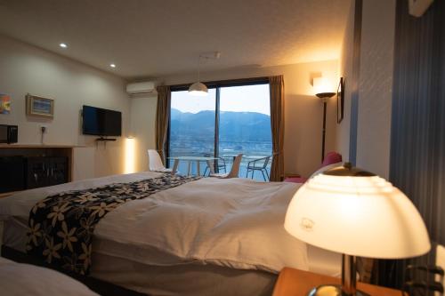 a hotel room with a bed and a large window at Gran Villa Rirera Haku in Yufu