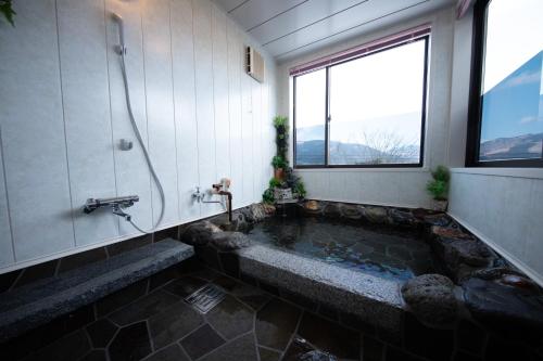 a bathroom with a large tub with a window at Gran Villa Rirera Haku in Yufu
