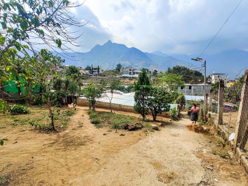 a person walking down a dirt road with mountains in the background at Casa Andres in San Juan La Laguna