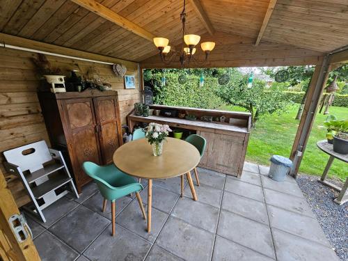 a patio with a table and chairs in a kitchen at Trekkershut - De Hollandse Boerderij in Ons Belang