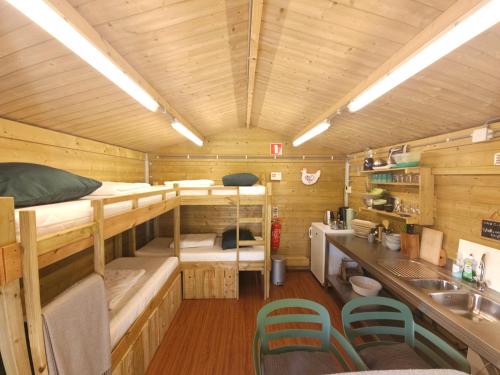 a room with two bunk beds and a sink in a cabin at Trekkershut - De Hollandse Boerderij in Ons Belang