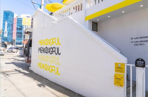 a white wall with writing on it on a street at Atelier PADO 102 in Busan