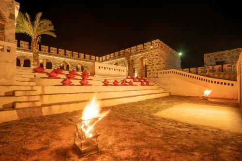 a fire pit in front of a building at night at Maya Luxury The Quila Udaipur in Udaipur