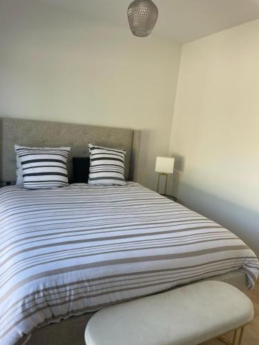 a bedroom with a large bed with striped pillows at Maison moderne avec Piscine in Creysse