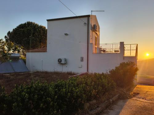 a white building with the sunset in the background at Belvedere in Santa Margherita di Belice