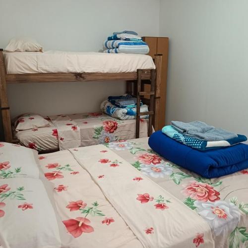two beds with flowers on them in a room at Hospedaje "Crisbel" en Las Catitas in Las Catitas