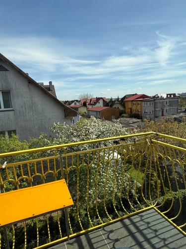 a yellow bench sitting on top of a balcony at Pensjonat Wiktoria in Międzywodzie