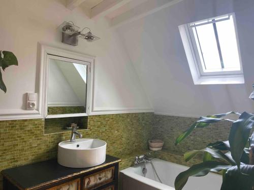 une salle de bain avec un lavabo, une baignoire et un miroir dans l'établissement Grande Maison à Semur en plein coeur Historique, à Semur-en-Auxois