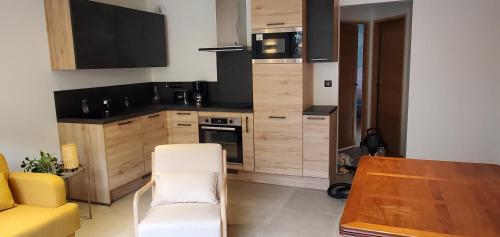 une petite cuisine avec une table et une chaise jaune dans l'établissement Maison confortable avec balcon et coin terrasse, à Allemont