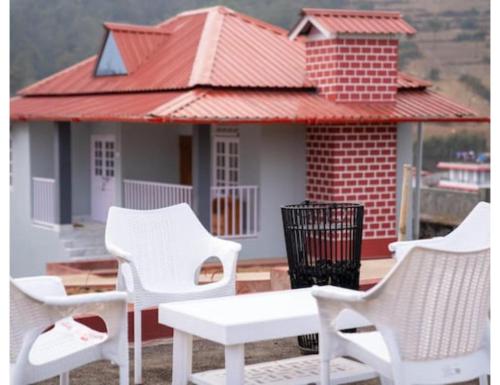 a group of white chairs and a table in front of a house at Le Nessa Guest House, Shillong in Shillong