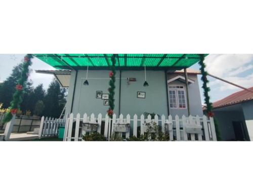 a white picket fence in front of a house at Le Nessa Guest House, Shillong in Shillong