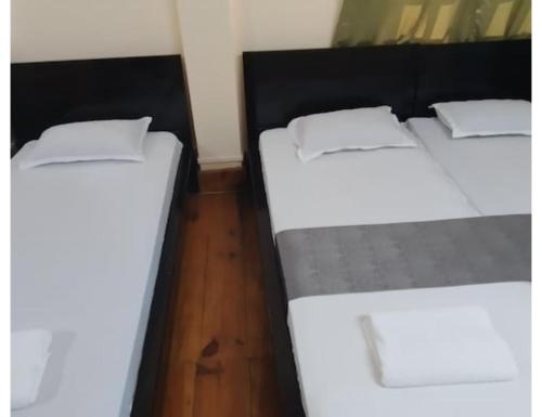 two beds sitting next to each other in a room at Le Nessa Guest House, Shillong in Shillong