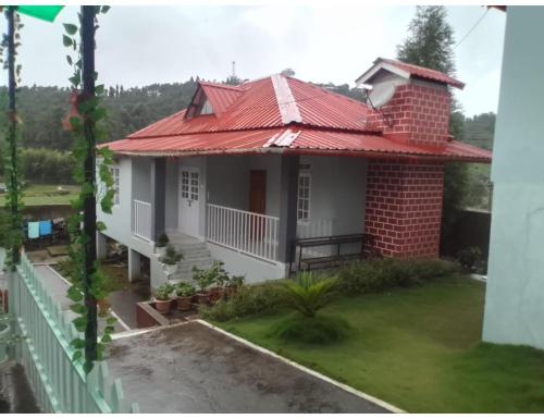 a small house with a red roof at Le Nessa Guest House, Shillong in Shillong