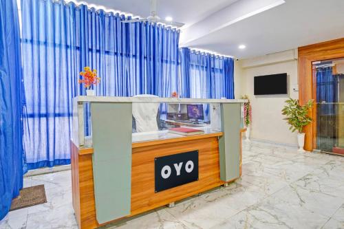 a oro counter in a room with blue curtains at Hotel O N R in Ahmedabad