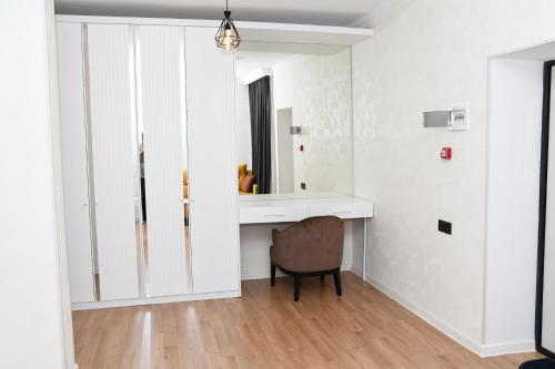 a white bathroom with a desk and a chair at Arena Hotel Gazakh in Qazax