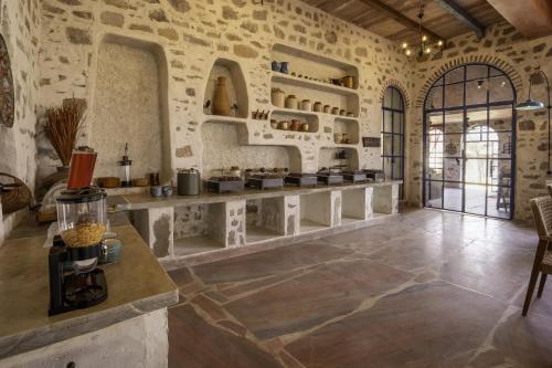 a kitchen with stone walls and a counter in a room at Maya Luxury The Quila Udaipur in Udaipur