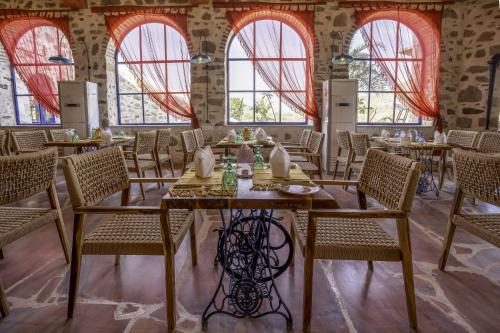 a dining room with tables and chairs and windows at Maya Luxury The Quila Udaipur in Udaipur