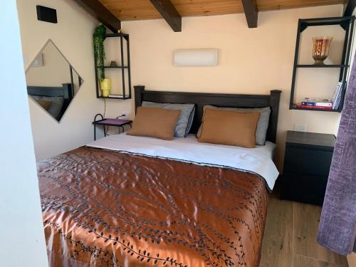 Schlafzimmer mit einem Bett mit zwei Spiegeln an der Wand in der Unterkunft Emanuela Chalets in Moshav Ramot
