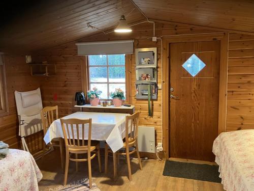 a dining room with a table and chairs in a cabin at Aggarps Stugor in Kulltorp