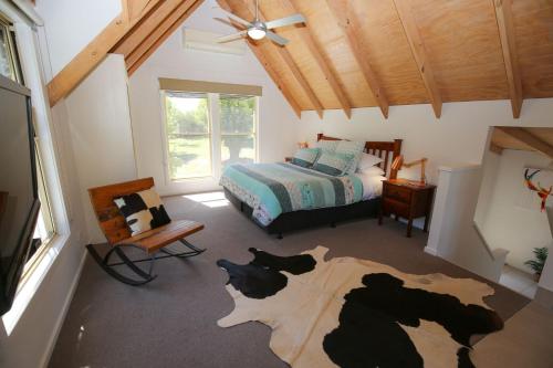 a bedroom with a bed with cows on the floor at Abby's Cottage - Cosy couples retreat in Wandiligong