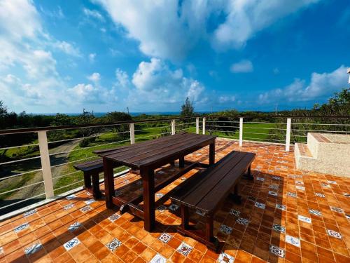 a wooden picnic table and benches on a patio at Kenting COMIC B&B&SPRING in Hengchun