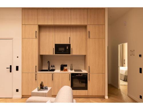 - une cuisine avec des placards en bois et un four micro-ondes dans l'établissement Résidence SAINTE ELISABETH MARAIS, à Paris