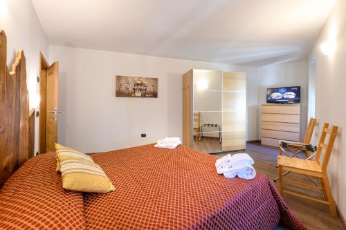 a bedroom with a bed with two towels on it at Hotel Garni Le Corti in Grosotto