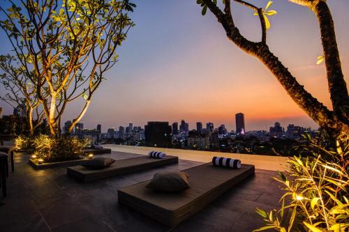 a rooftop patio with a view of the city at sunset at GLOW PARK HOTEL Grand Royal Palace in Phnom Penh