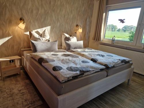 a bedroom with a large bed with a window at Haus am Willenberg in Warmsen