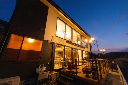 a house with a balcony with lights on it at Gran Villa Rirera Towa in Yufu