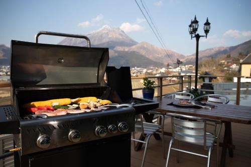 a grill with food on it on a balcony at Gran Villa Rirera Towa in Yufu