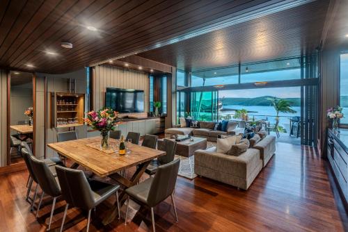 a dining room and living room with a table and chairs at Yacht Club Villas on Hamilton Island by HIHA in Hamilton Island