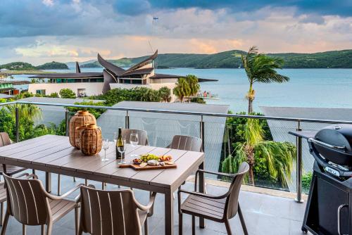 a table with a plate of food on a balcony at Yacht Club Villas on Hamilton Island by HIHA in Hamilton Island