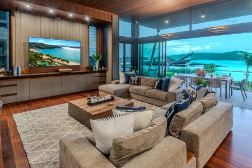 a living room with two couches and a table at Yacht Club Villas on Hamilton Island by HIHA in Hamilton Island
