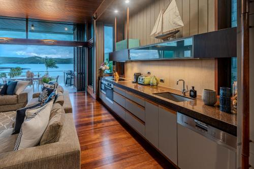 a kitchen with a couch and a sink in a room at Yacht Club Villas on Hamilton Island by HIHA in Hamilton Island