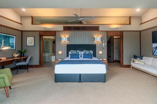 a bedroom with a large bed and a couch at Yacht Club Villas on Hamilton Island by HIHA in Hamilton Island