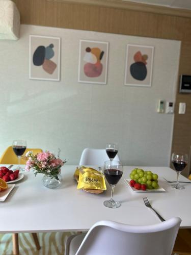 a table with glasses of wine and fruit on it at Gamseong house next to Sung Sim Dang in Daejeon