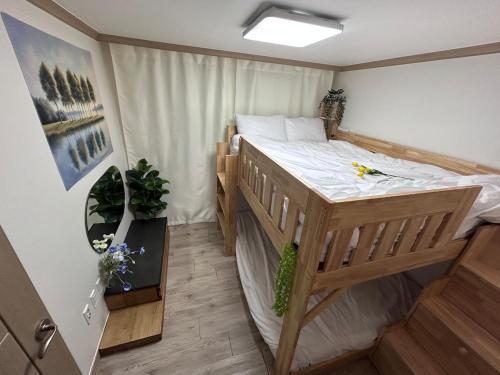 a bedroom with a wooden bed in a room at Gamseong house next to Sung Sim Dang in Daejeon