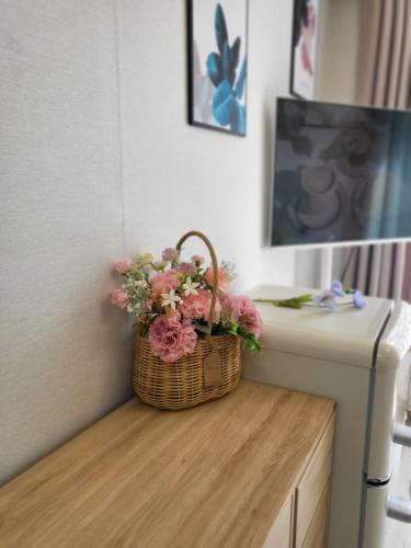 a basket of flowers sitting on a counter next to a refrigerator at Gamseong house next to Sung Sim Dang in Daejeon