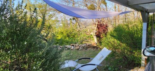 a white chair sitting in a yard with a canopy at Le Coq de Champagne in Dormans