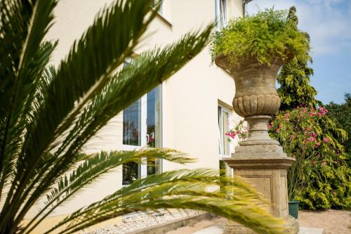 a plant on a pillar in front of a building at Mediterran Hotel Juwel in Karlstein am Main