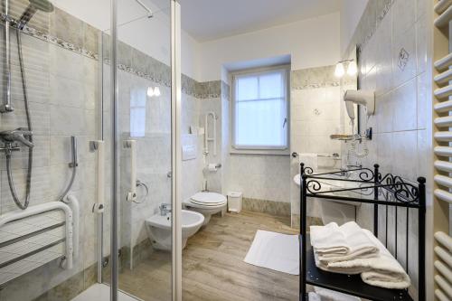 a bathroom with a glass shower and a toilet at Hotel Garni Le Corti in Grosotto