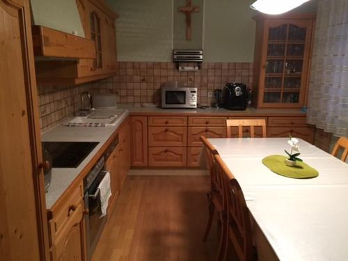 eine Küche mit Holzschränken und einer weißen Arbeitsplatte in der Unterkunft Haus Tina Zimmer in Niklasdorf