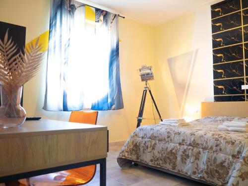 a bedroom with a bed and a table with a camera at Affittacamere DaME in Foligno